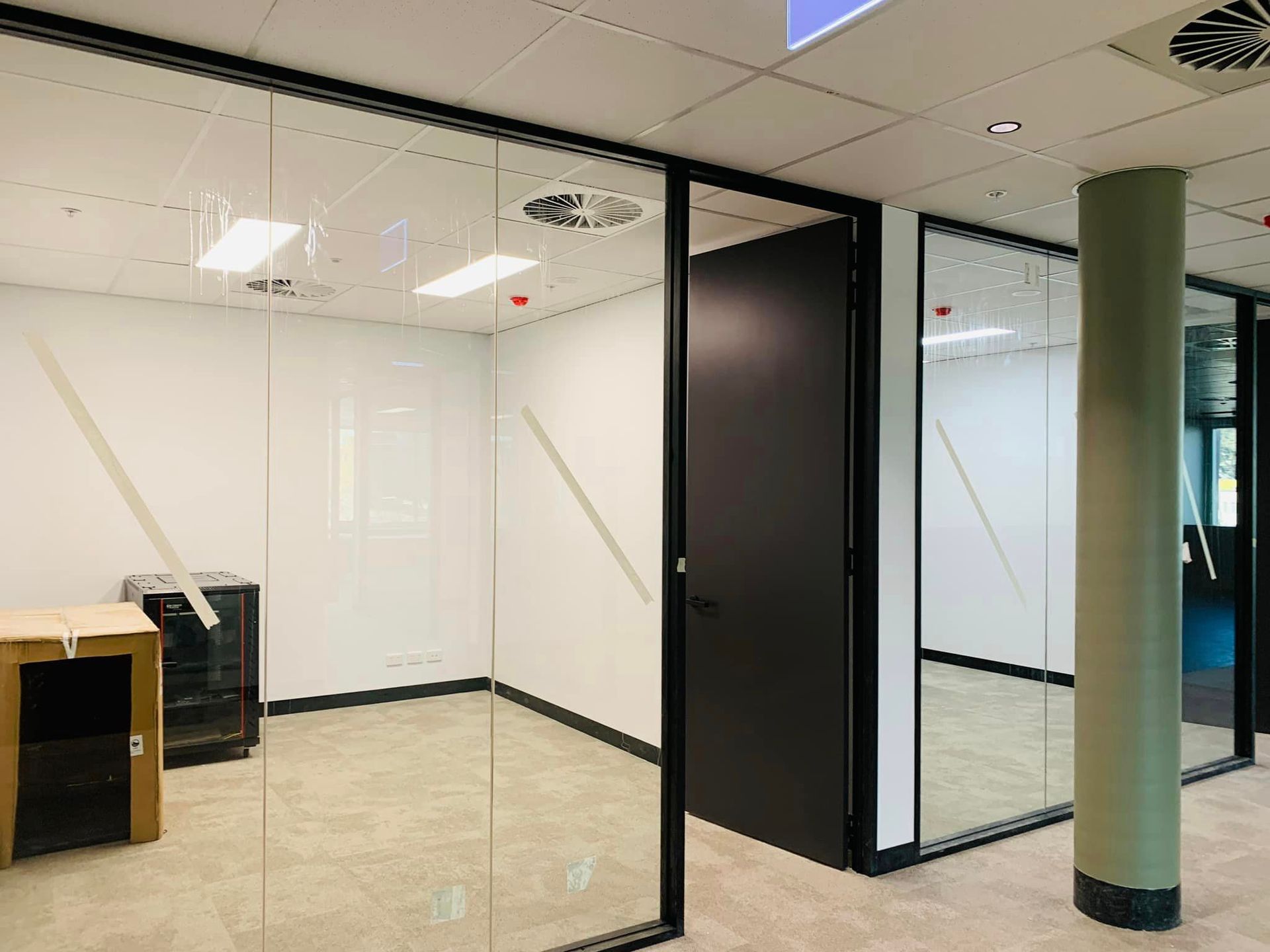 A room with a lot of glass walls and a black door.