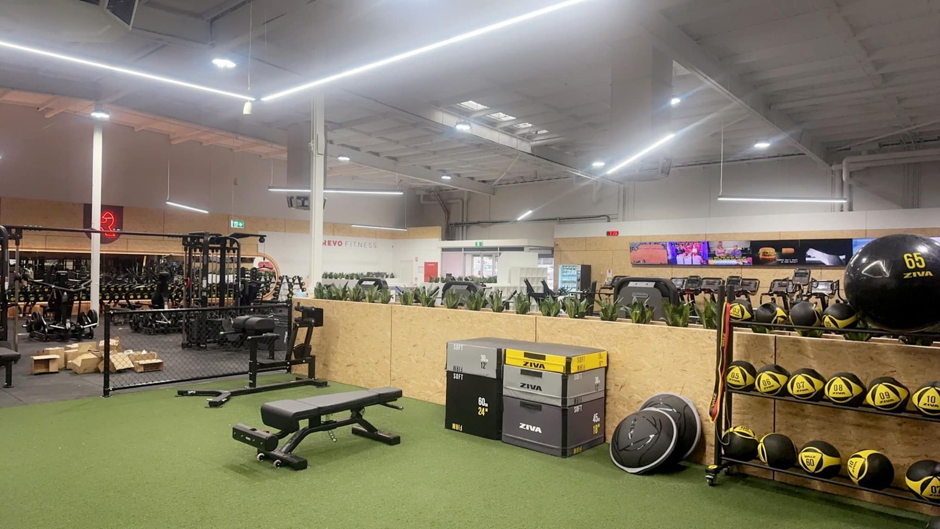 A gym with a lot of exercise equipment and a bench.