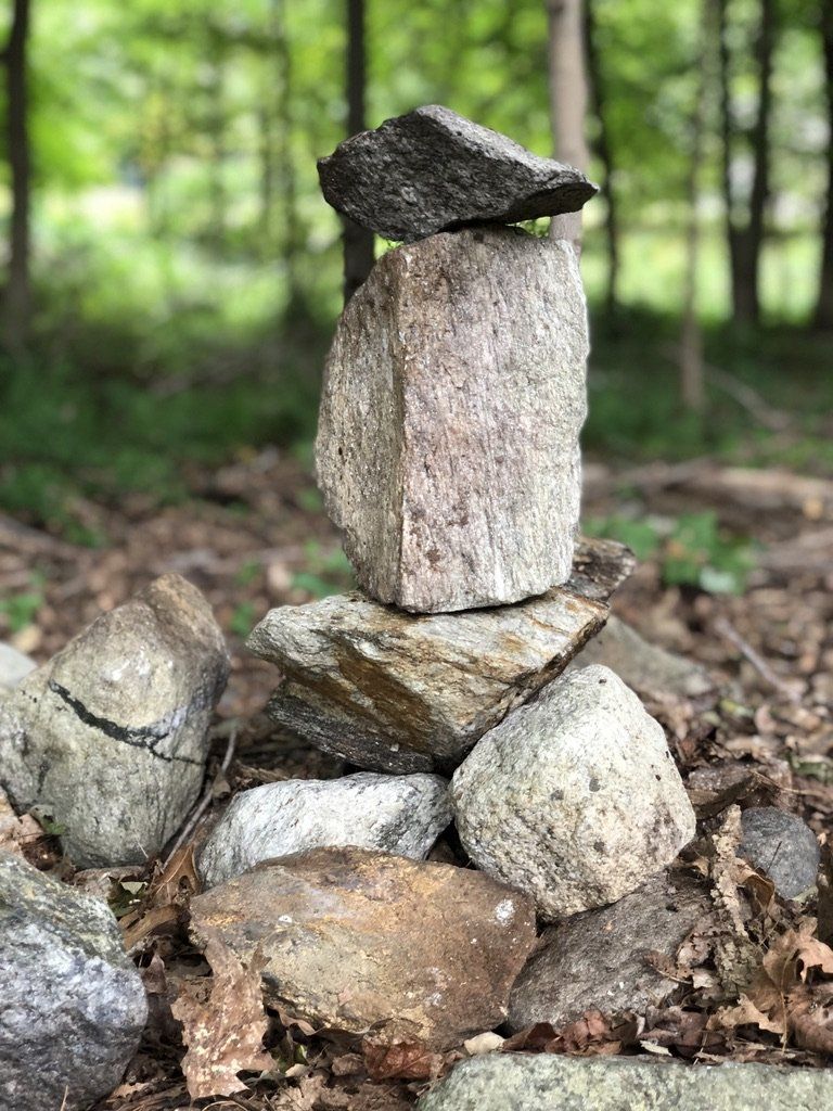 A pile of rocks stacked on top of each other in the woods.