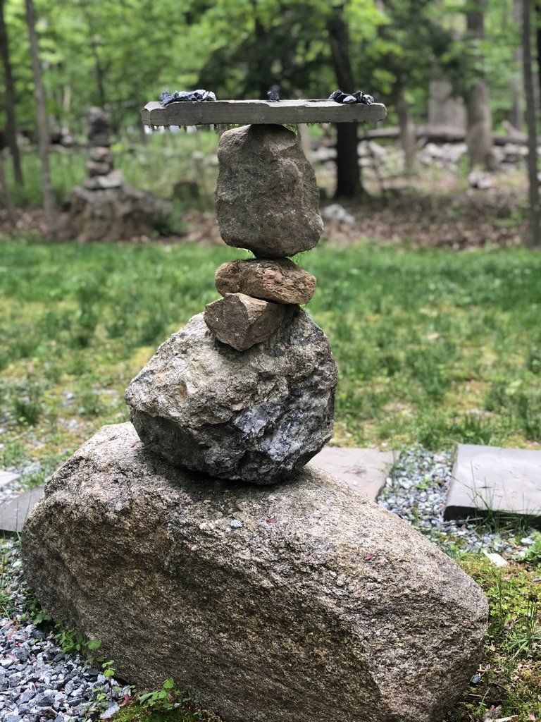A stack of rocks sitting on top of each other in a yard.