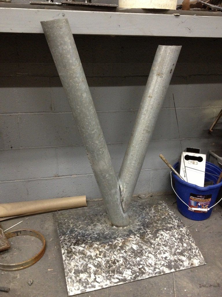 Two metal pipes are sitting on top of a metal base.