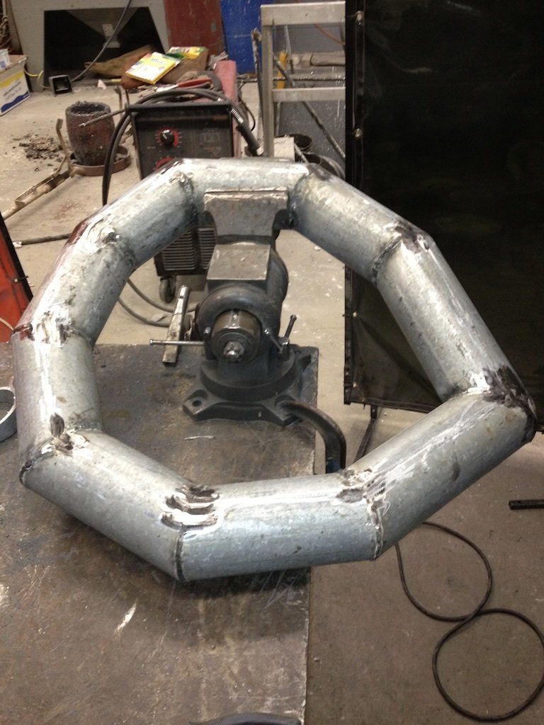 A piece of metal is sitting on a table next to a vise.