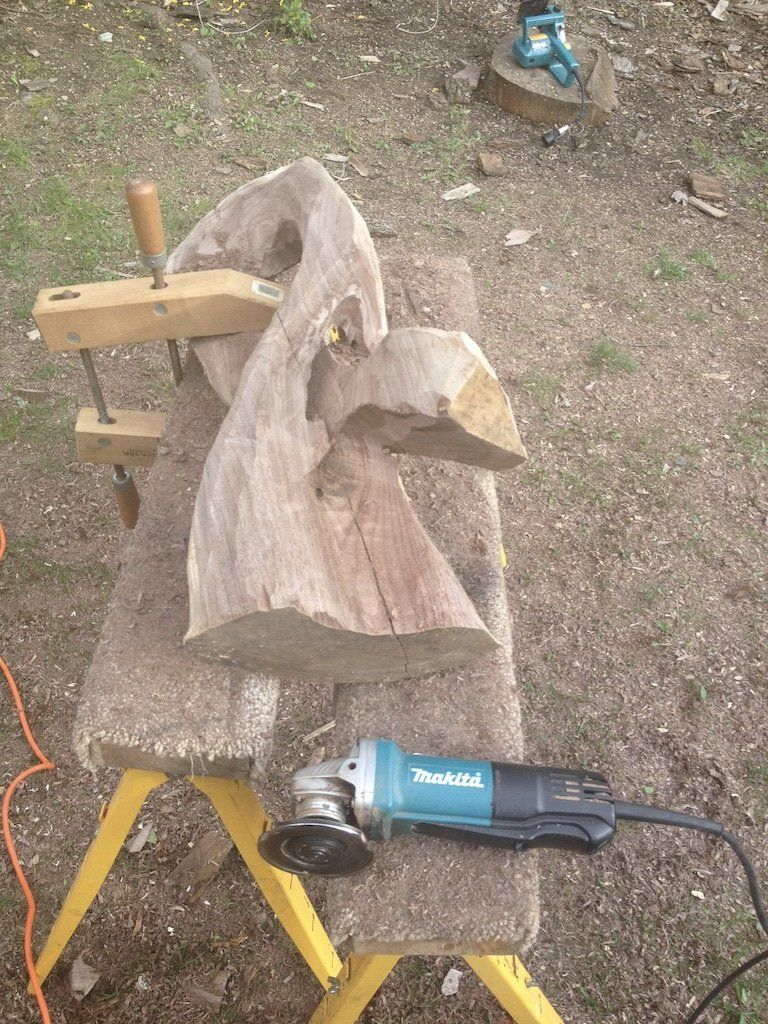 A piece of wood is sitting on a table next to a grinder.
