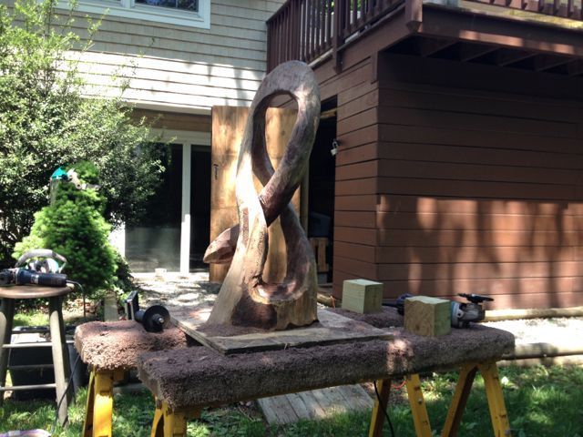A sculpture is sitting on a table in front of a house