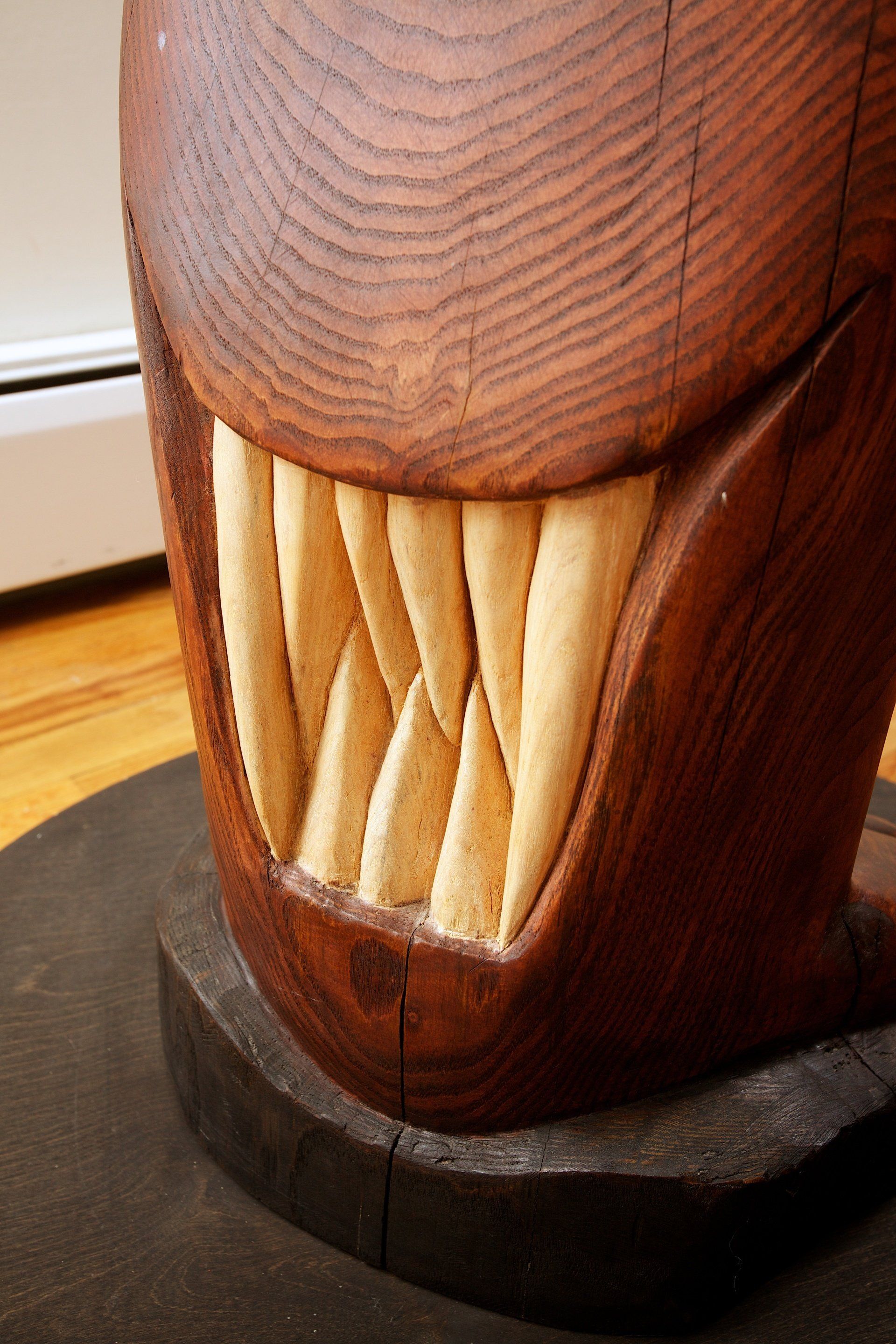 A close up of a wooden sculpture with sharp teeth
