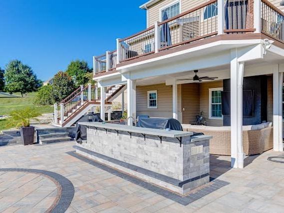Custom paver patio with built-in seating in a backyard in Bel Air, MD - Xscape 2 Nature Outdoor Design and Landscaping