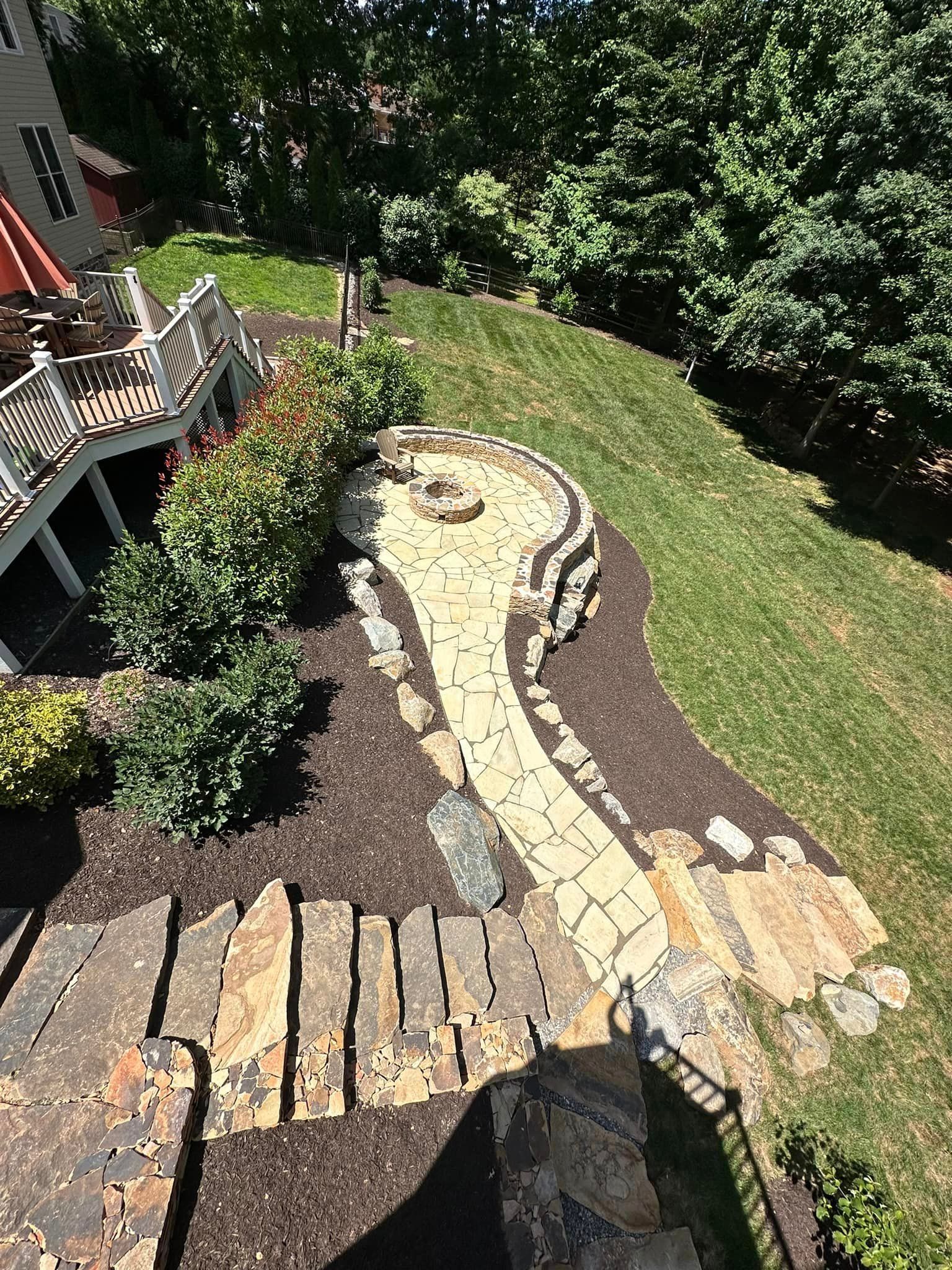 Stone walkway and outdoor fireplace installed by Xscape 2 Nature, expert hardscaping contractors in Maryland.