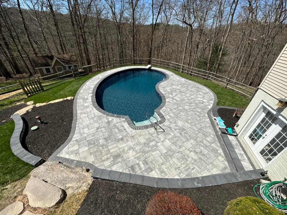 Outdoor Living Space in Jarrettsville, MD A large swimming pool with a triangle shaped border