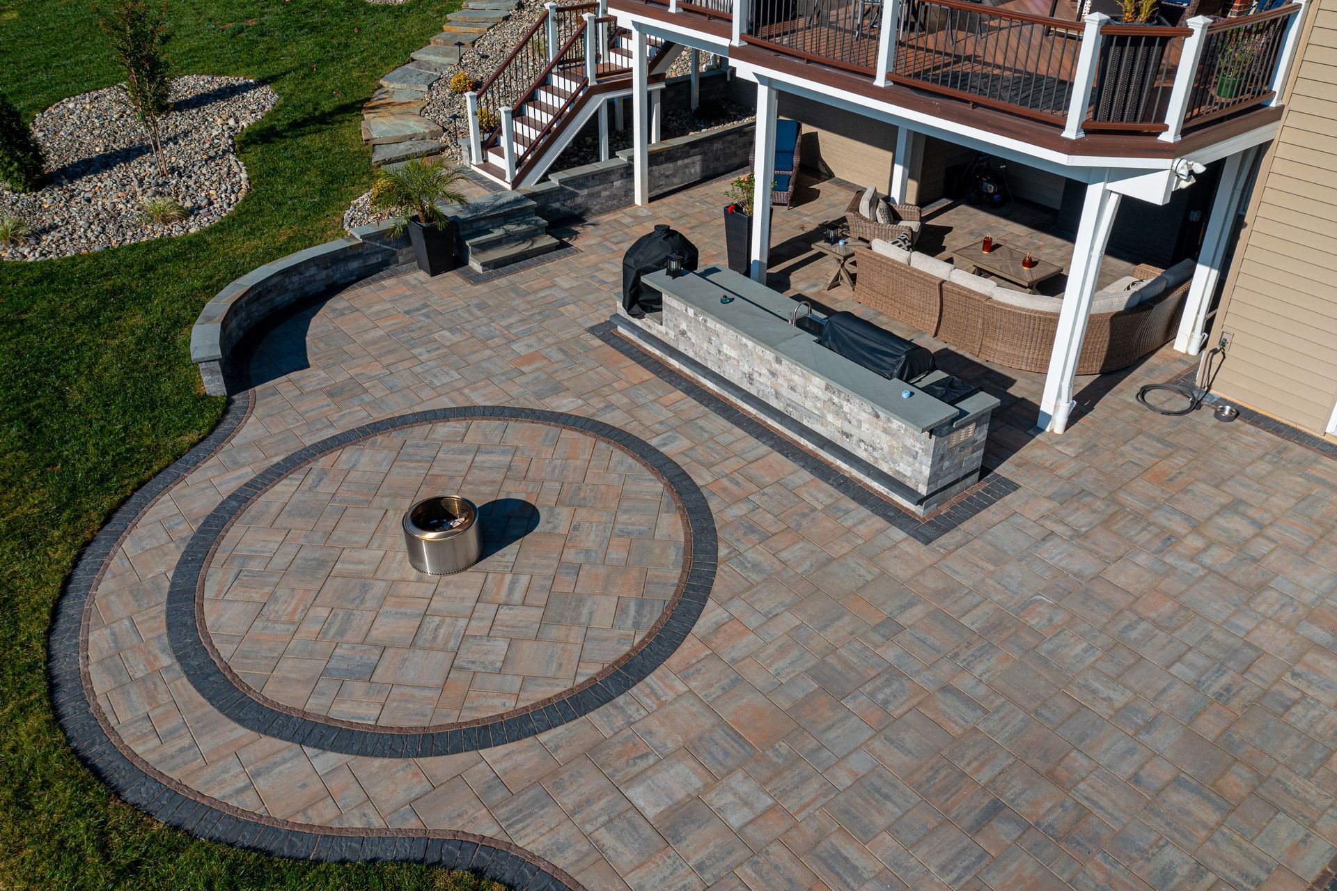 Custom multi-functional patio with fire pit and outdoor kitchen built by Xscape 2 Nature in Maryland, designed for year-round outdoor living and entertaining.