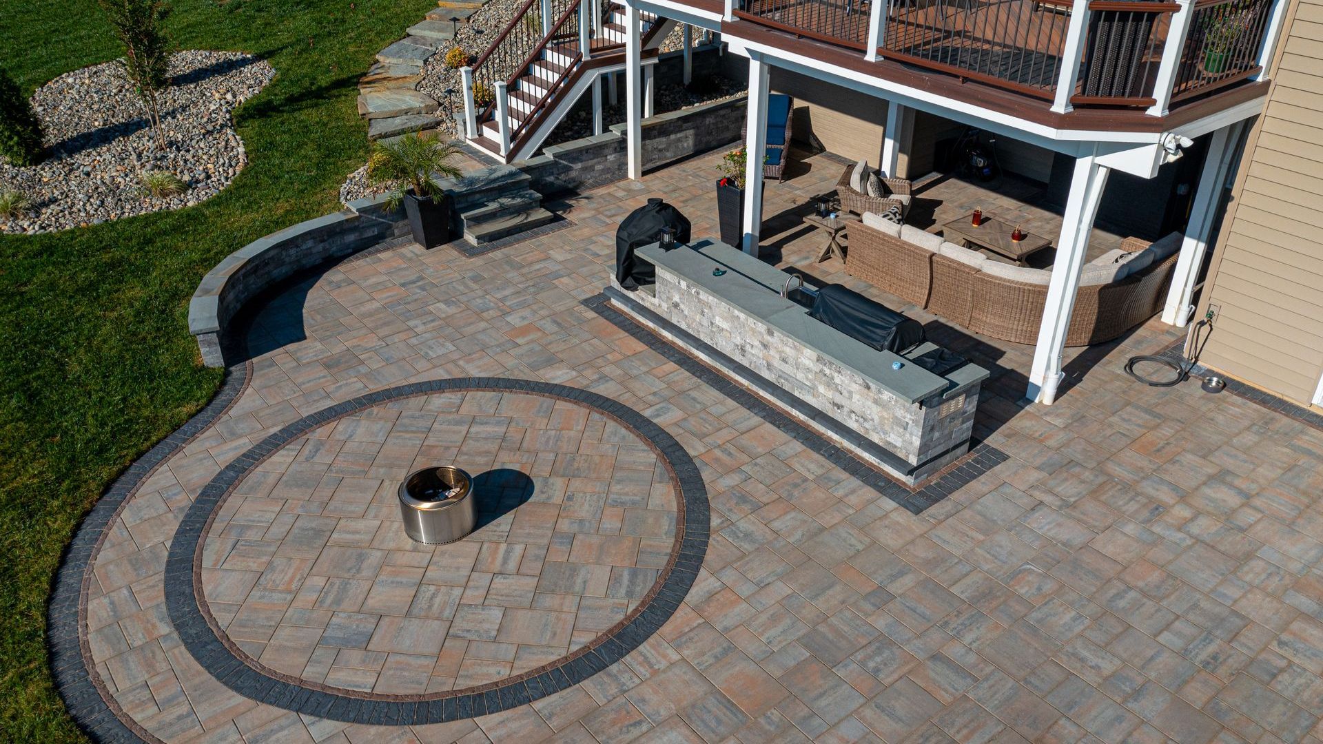 Outdoor living space in Maryland with a fire pit, lounge area, deck, and outdoor kitchen installed b