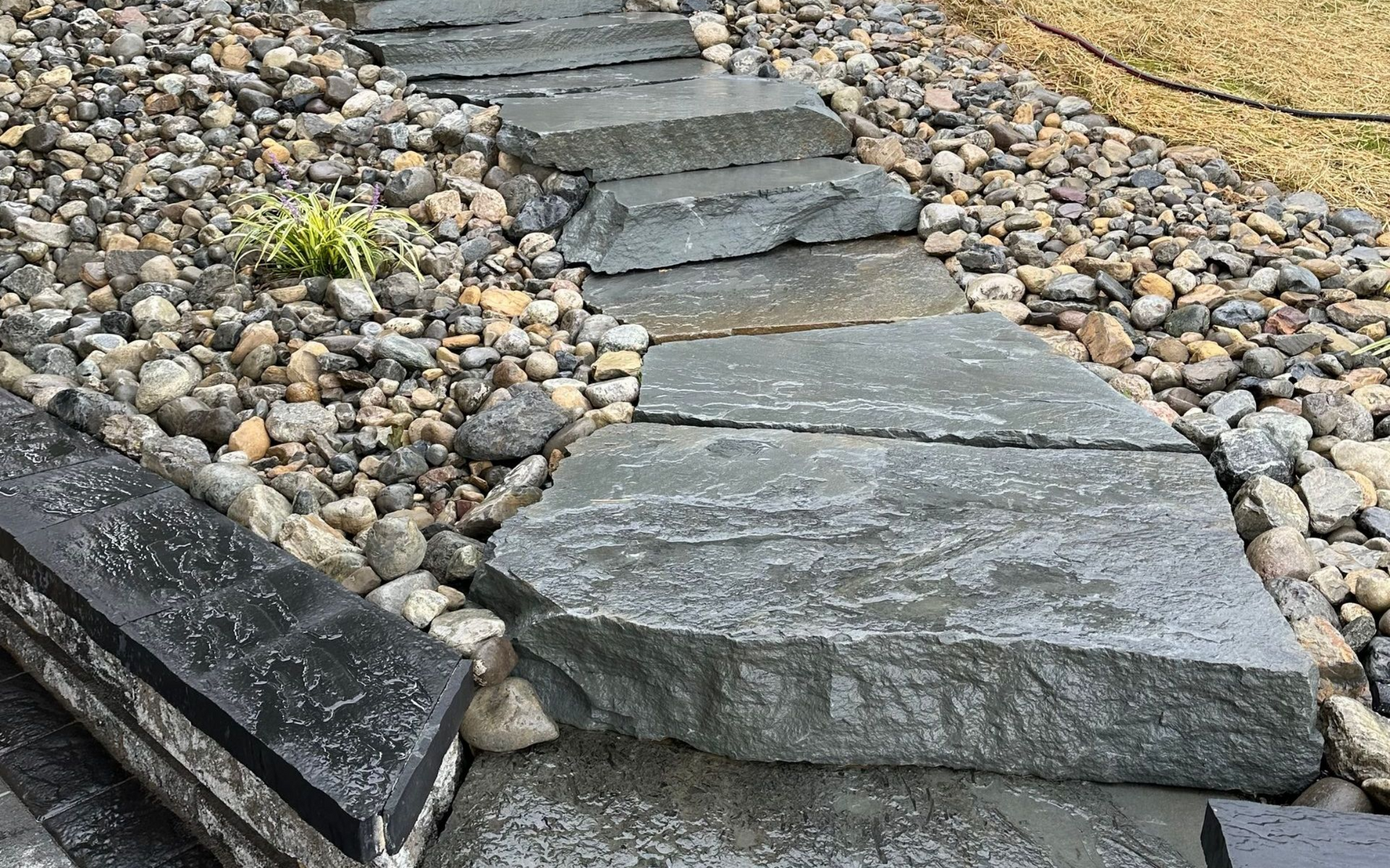 Stone path and staircase leading uphill through gravel and rocks. Installed by X2N