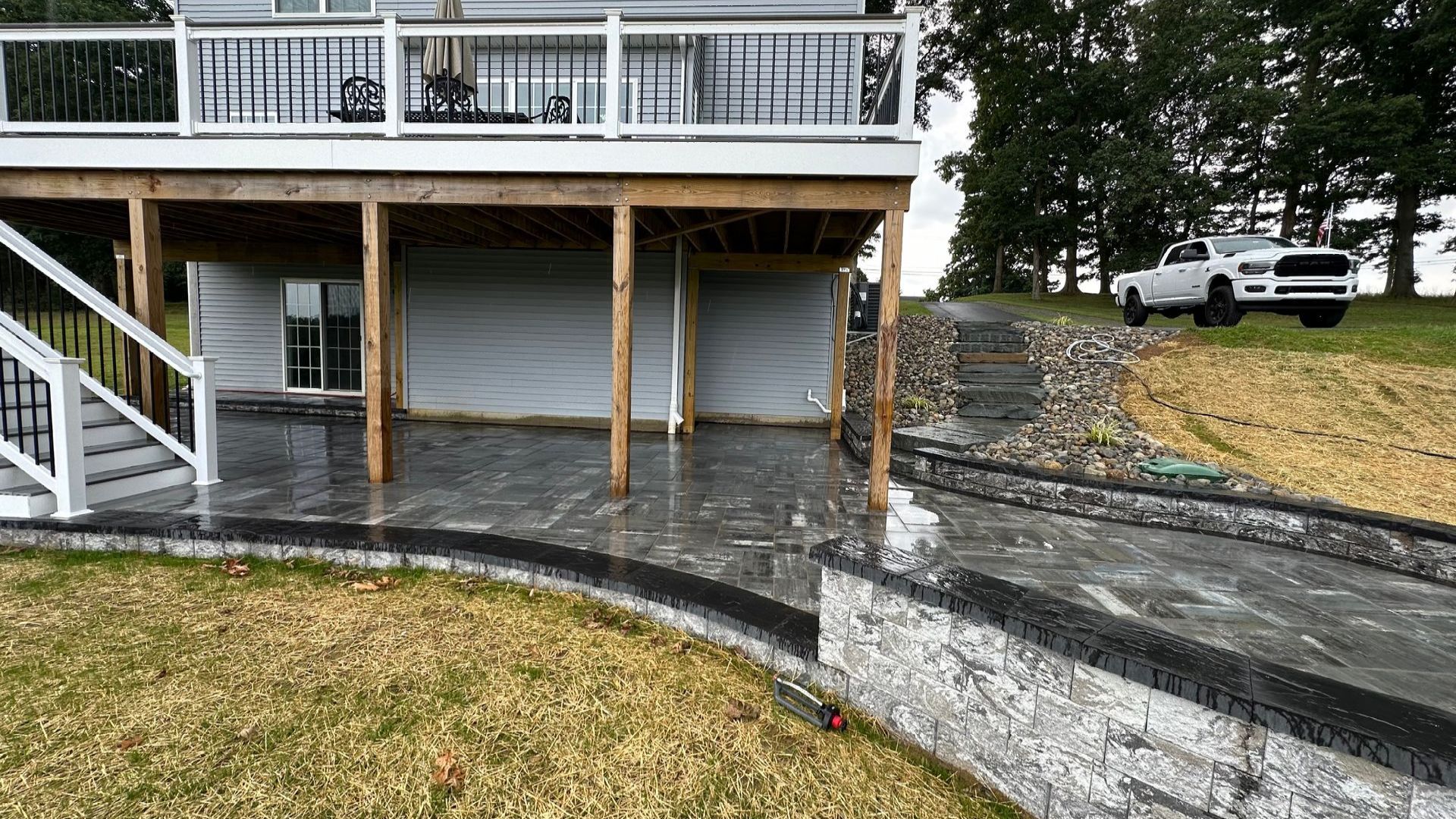 Newly installed patio and retaining wall showcasing expert hardscaping design in Maryland backyard.