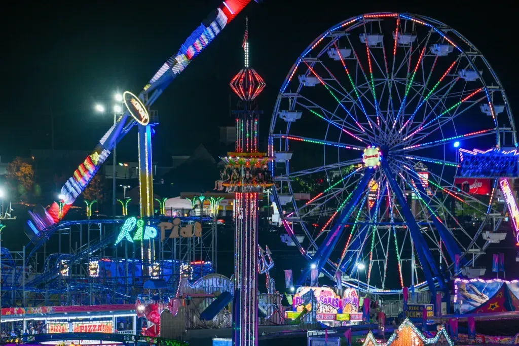 Ferris wheel and other rides illuminated at night during the 2025 Maryland State Fair in Timonium, Maryland.