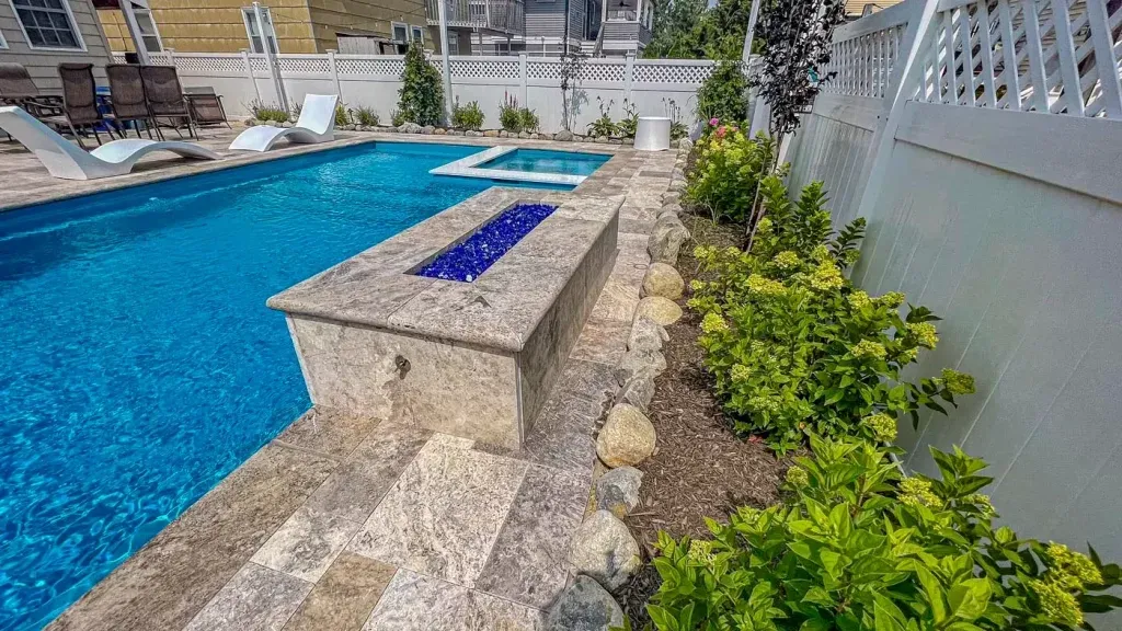 A large swimming pool with a fire pit in the middle of it.