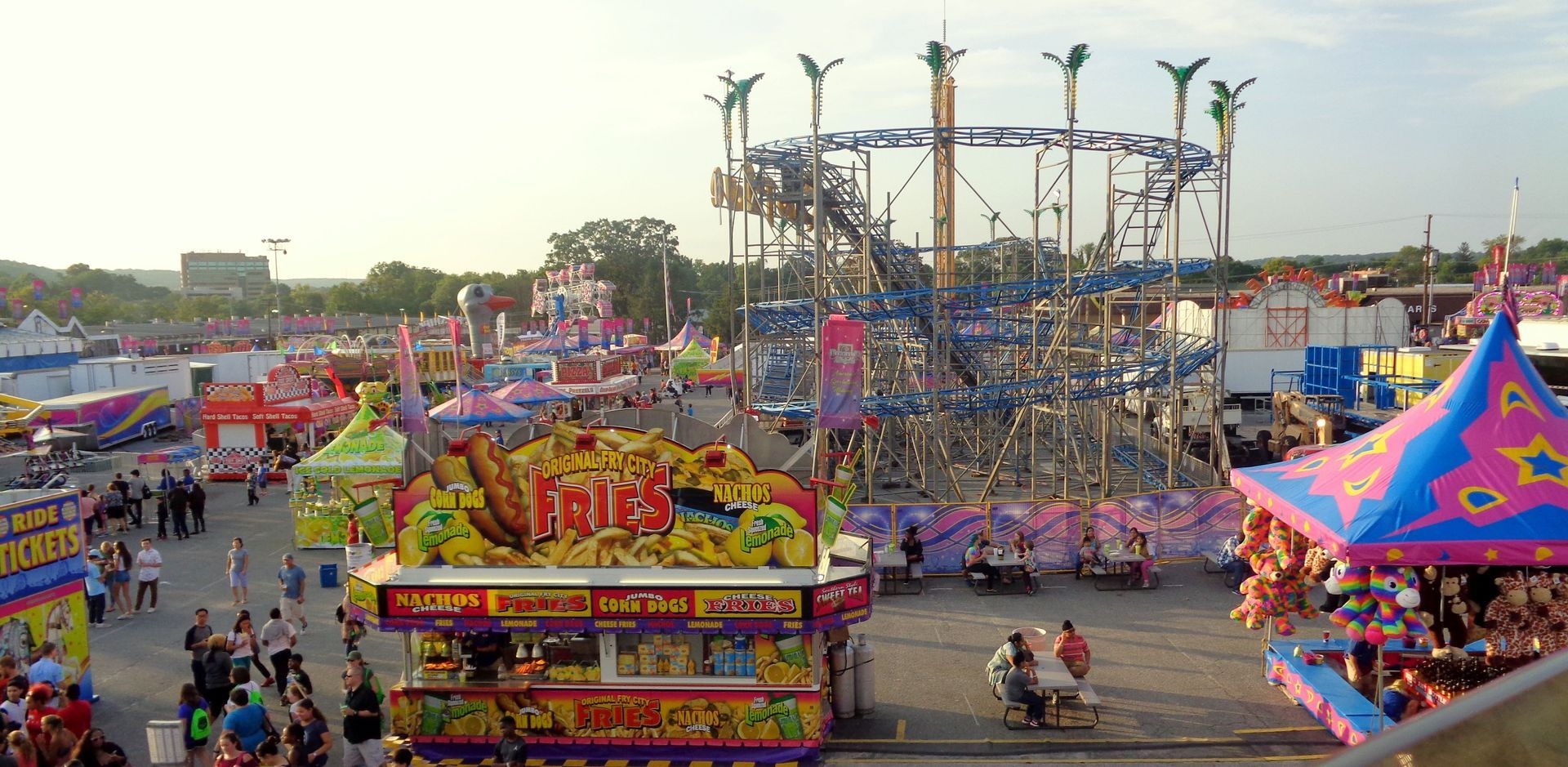 Visitors enjoying carnival rides and roller coasters at the Maryland State Fair.