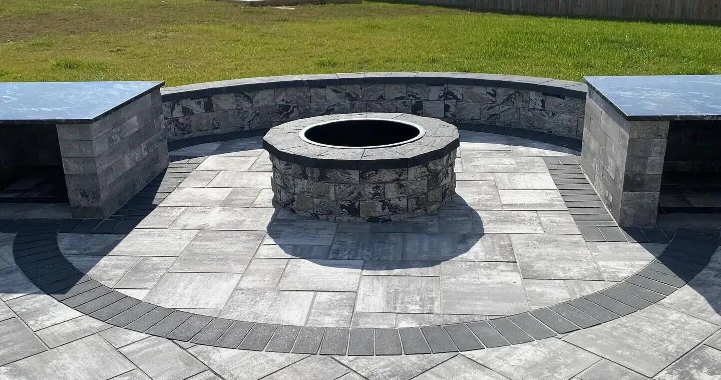 Custom patio with outdoor fireplace and retaining wall built by Xscape 2 Nature in Maryland