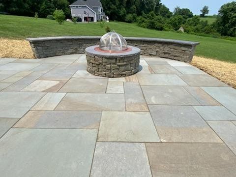 A patio with a fire pit and a fountain in the middle of it.