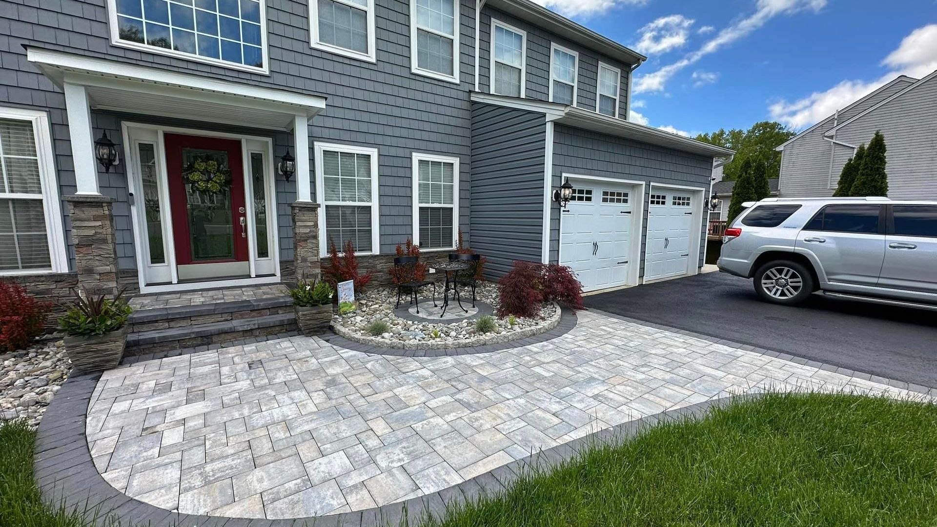 A car is parked in front of a house with a walkway.
