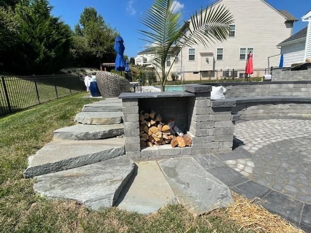 There is a fireplace in the backyard with stairs leading up to it.
