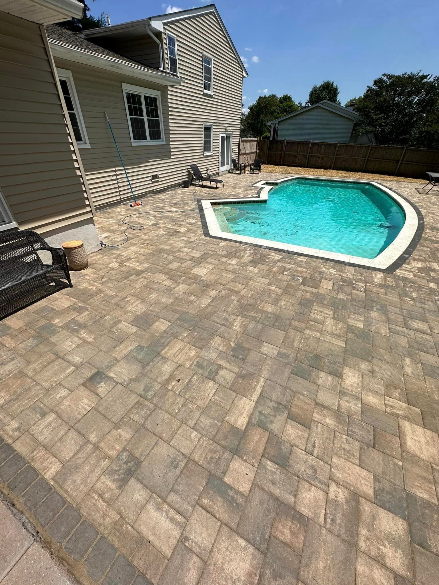 There is a large swimming pool in the backyard of a house.