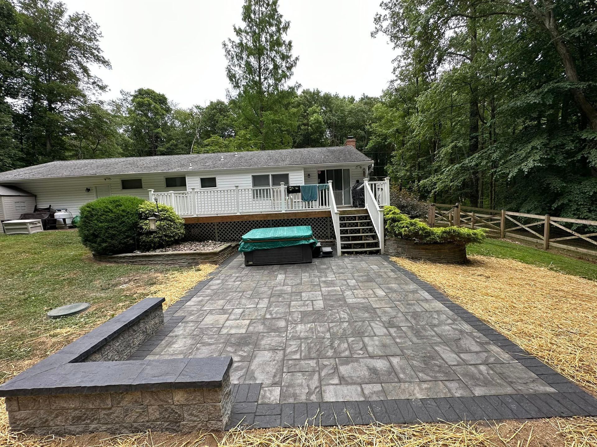 A large patio with a fire pit in front of a house.