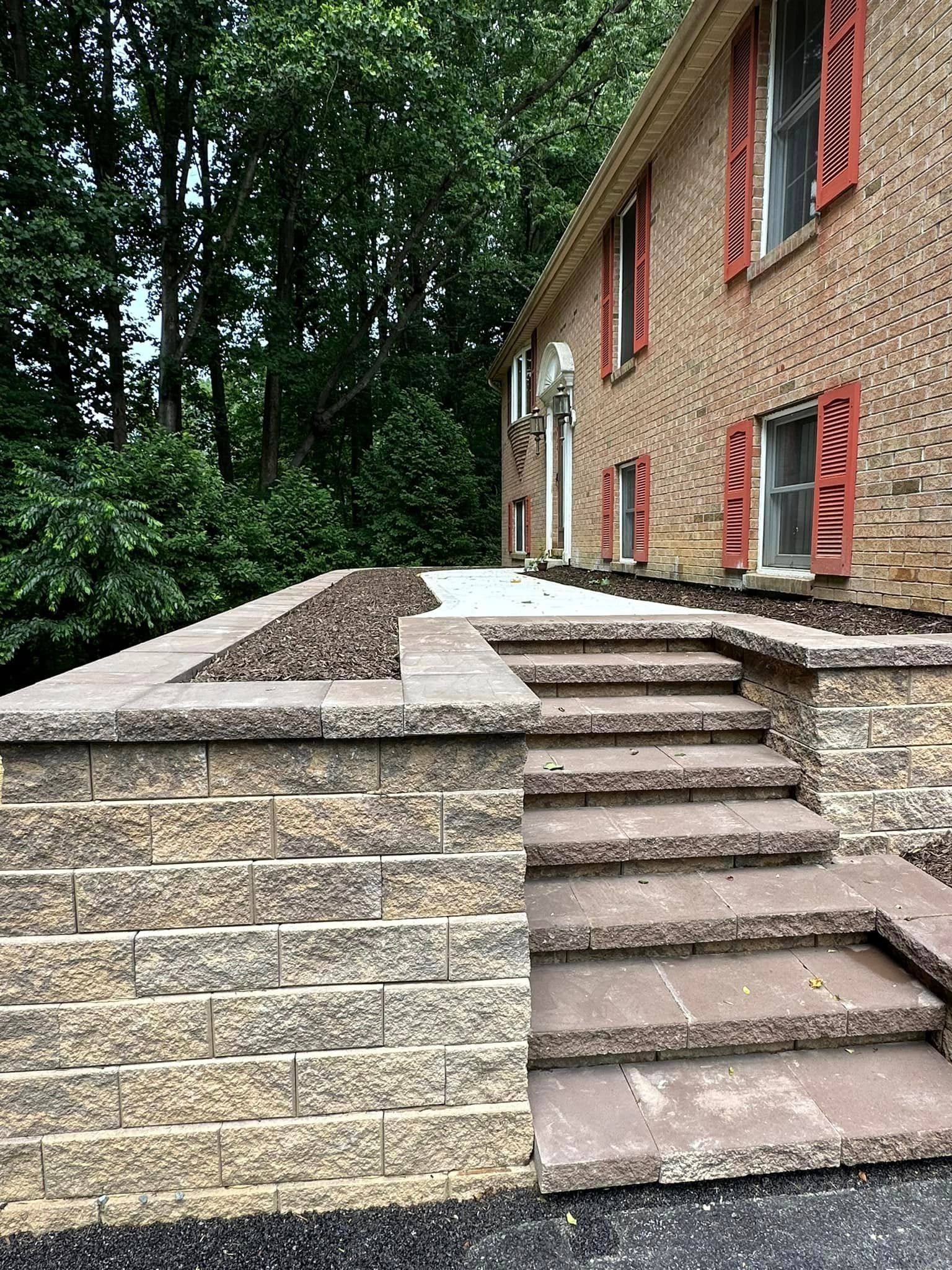 A brick wall with stairs leading up to a house.