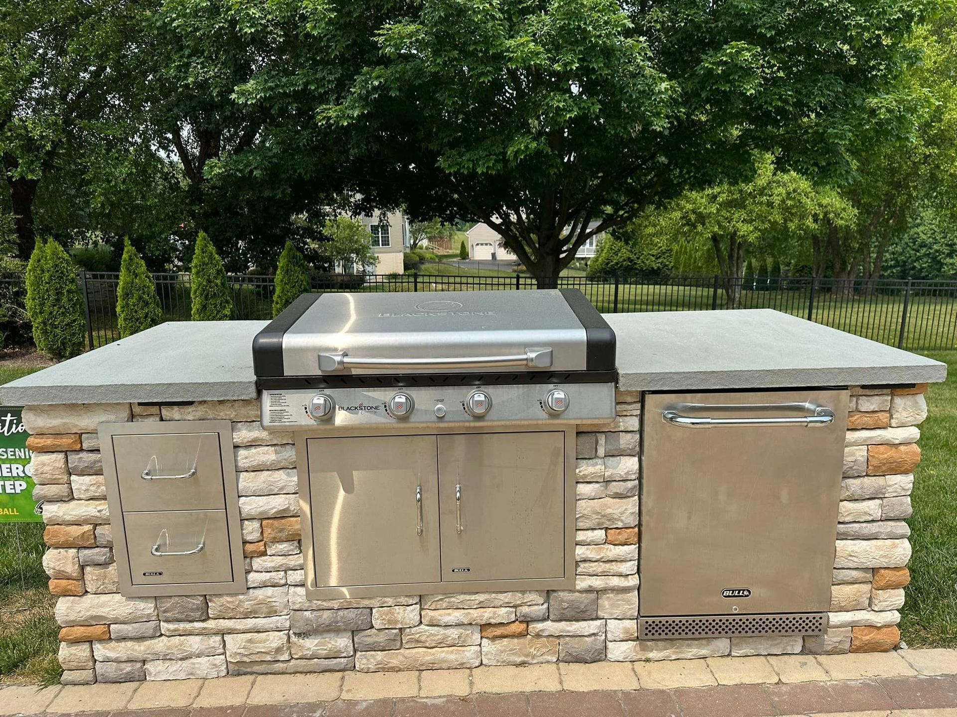 A stainless steel grill is sitting on top of a stone counter.