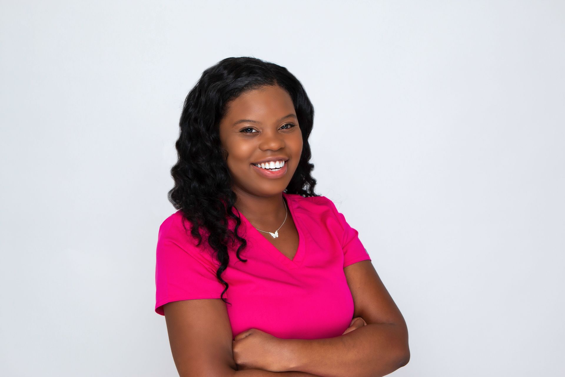 A woman in a blue and white floral shirt is smiling for the camera.
