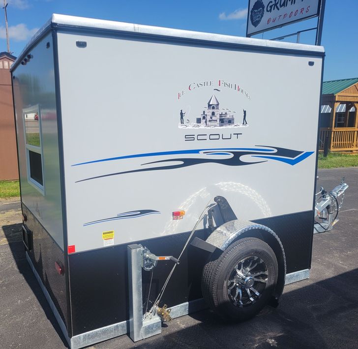 Ice fishing trailer, gray and black with graphics, in front of a building.