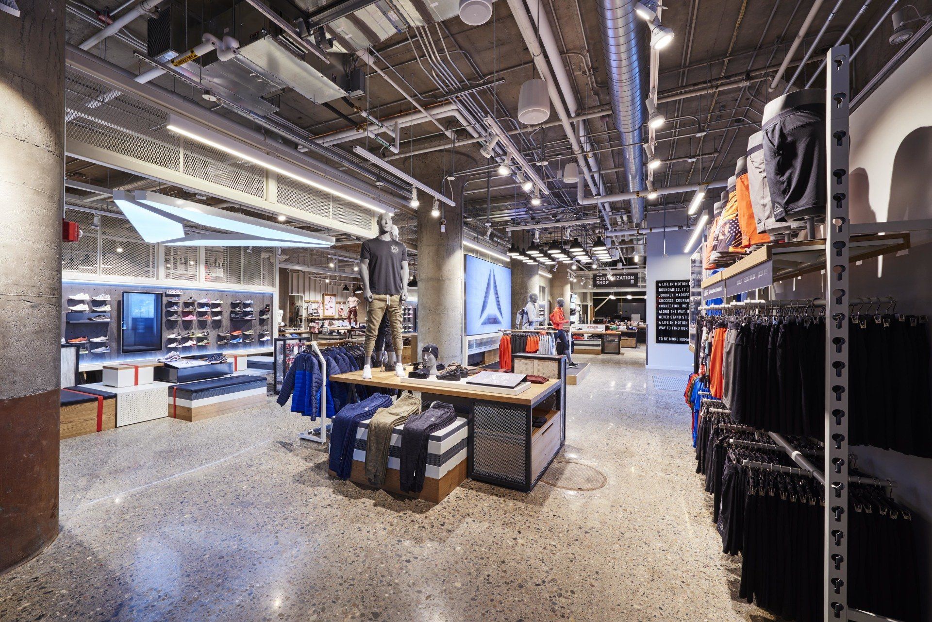 The inside of a reebok store with a lot of clothes on display.