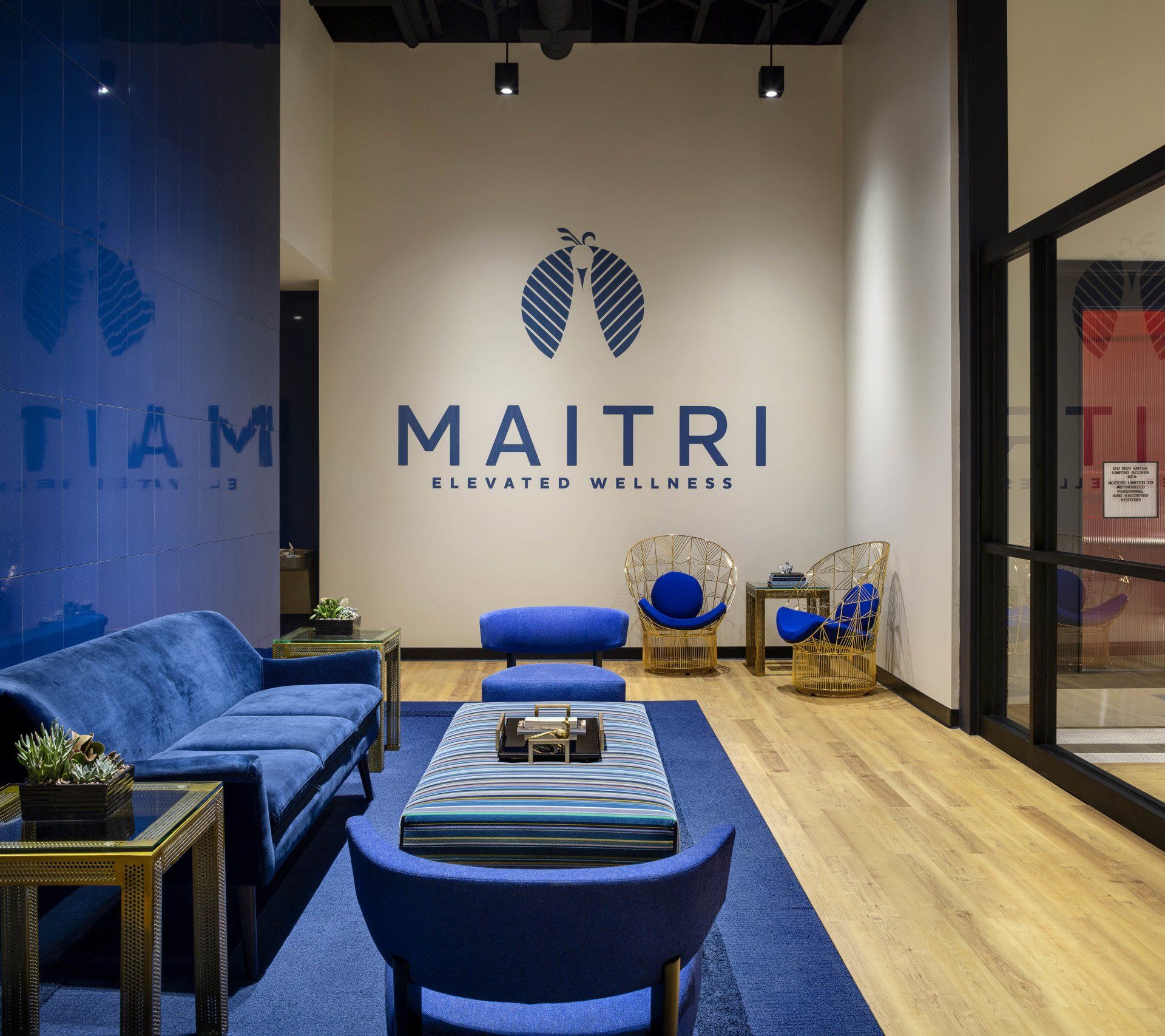 A living room with blue furniture and a wall that says maitri