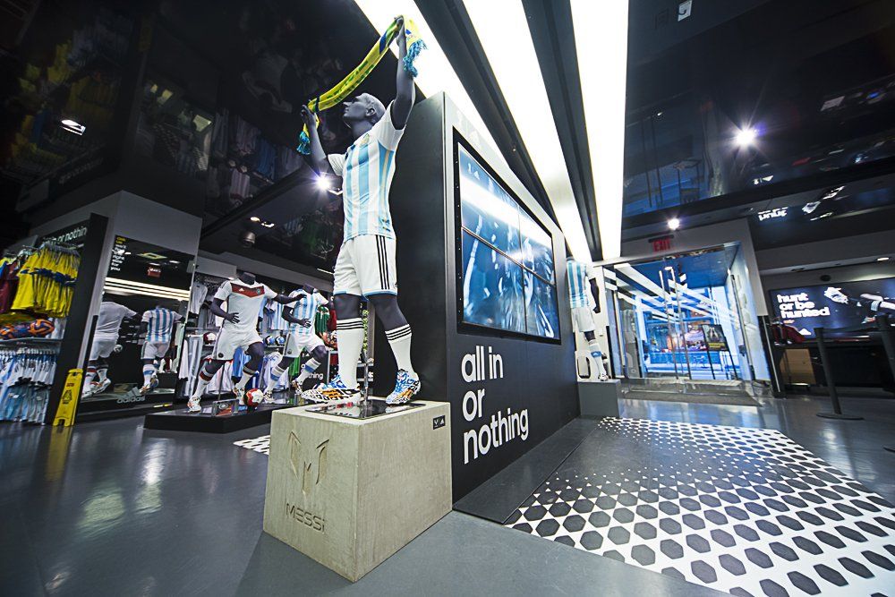 A statue of a soccer player holding a trophy in a store.