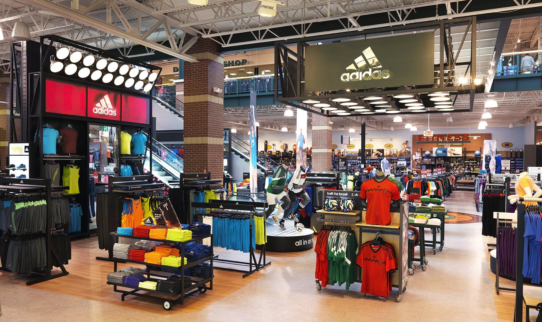 A large adidas store with lots of shirts on display