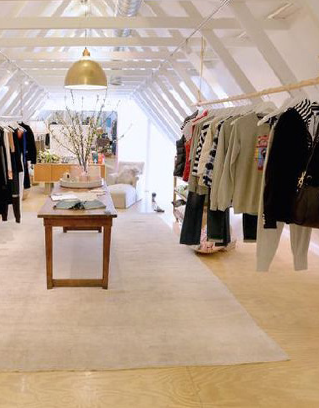 A store with clothes hanging on racks and a table