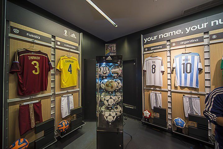 A room with a lot of soccer jerseys hanging on the wall.