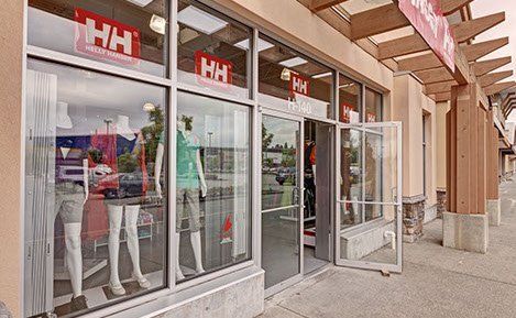 A store front with a lot of windows and mannequins in the window.