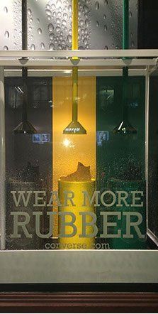 A window display with a sign that says `` wear more rubber ''.