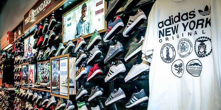 A adidas new york original t-shirt is hanging on a wall in a store.