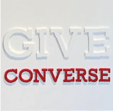 A white sign that says give converse in red letters