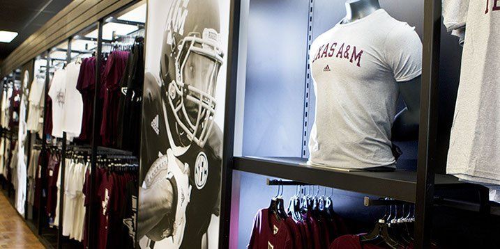 A display of football jerseys in a store with a picture of a football player on the wall.