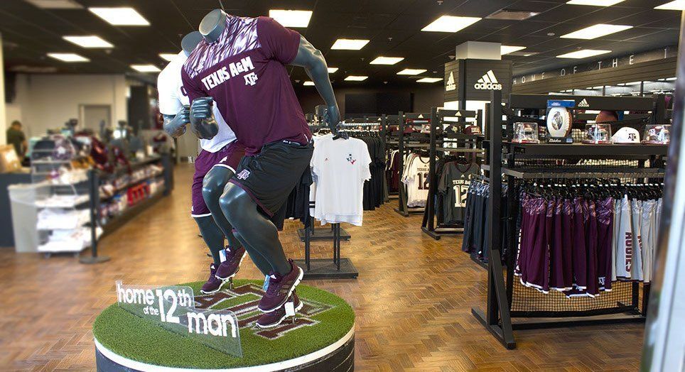 A mannequin is standing on top of a football field in a store.