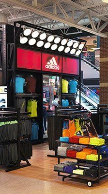 A large adidas store with a lot of clothes on display.