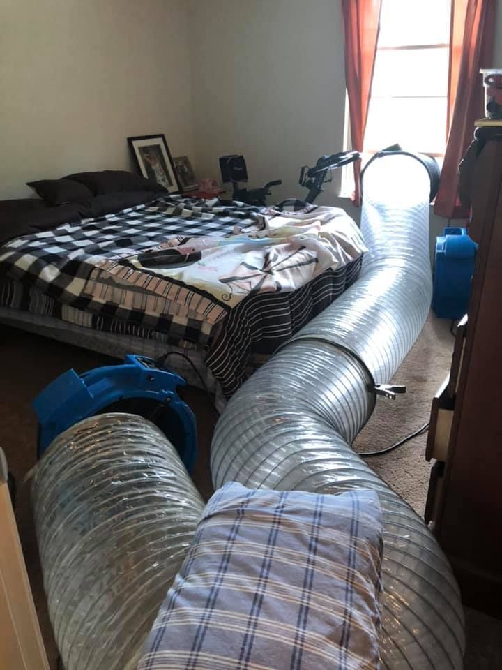 A bedroom with a bed and a hose coming out of it.