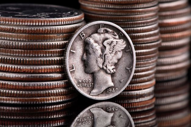 Mercury dime leaning against a stack of coins