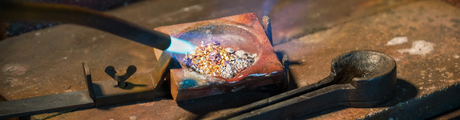 Goldsmith melting gold and silver granules in a crucible