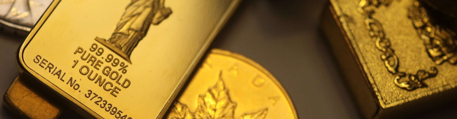 miscellaneous gold bullion bars and coins on a surface