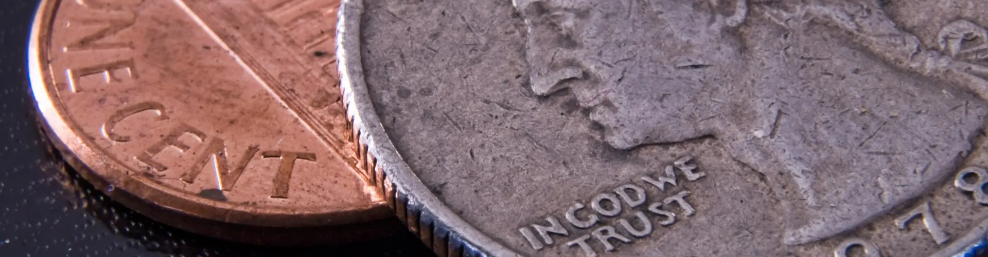 Quarter, penny sitting on a black background