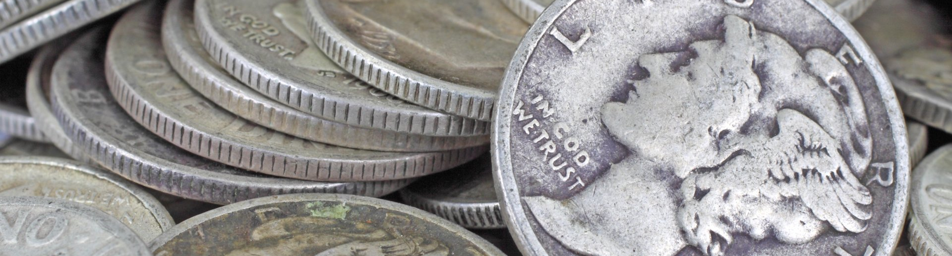 obverse of mercury dime shown leaning against a stack of more mercury dimes