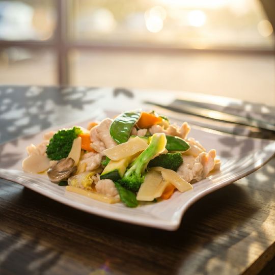 Plate of colorful vegetable and rice dish on a table in warm sunlight