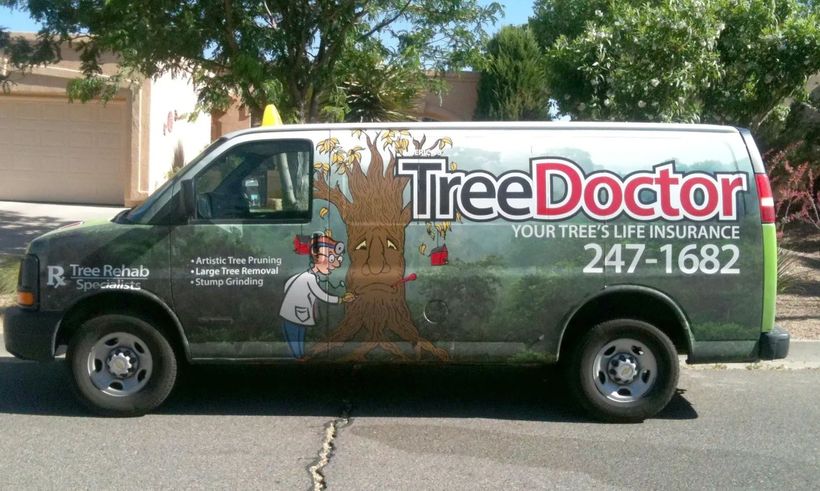 Tree Doctor service van parked outdoors, with large logo and phone number on the side.